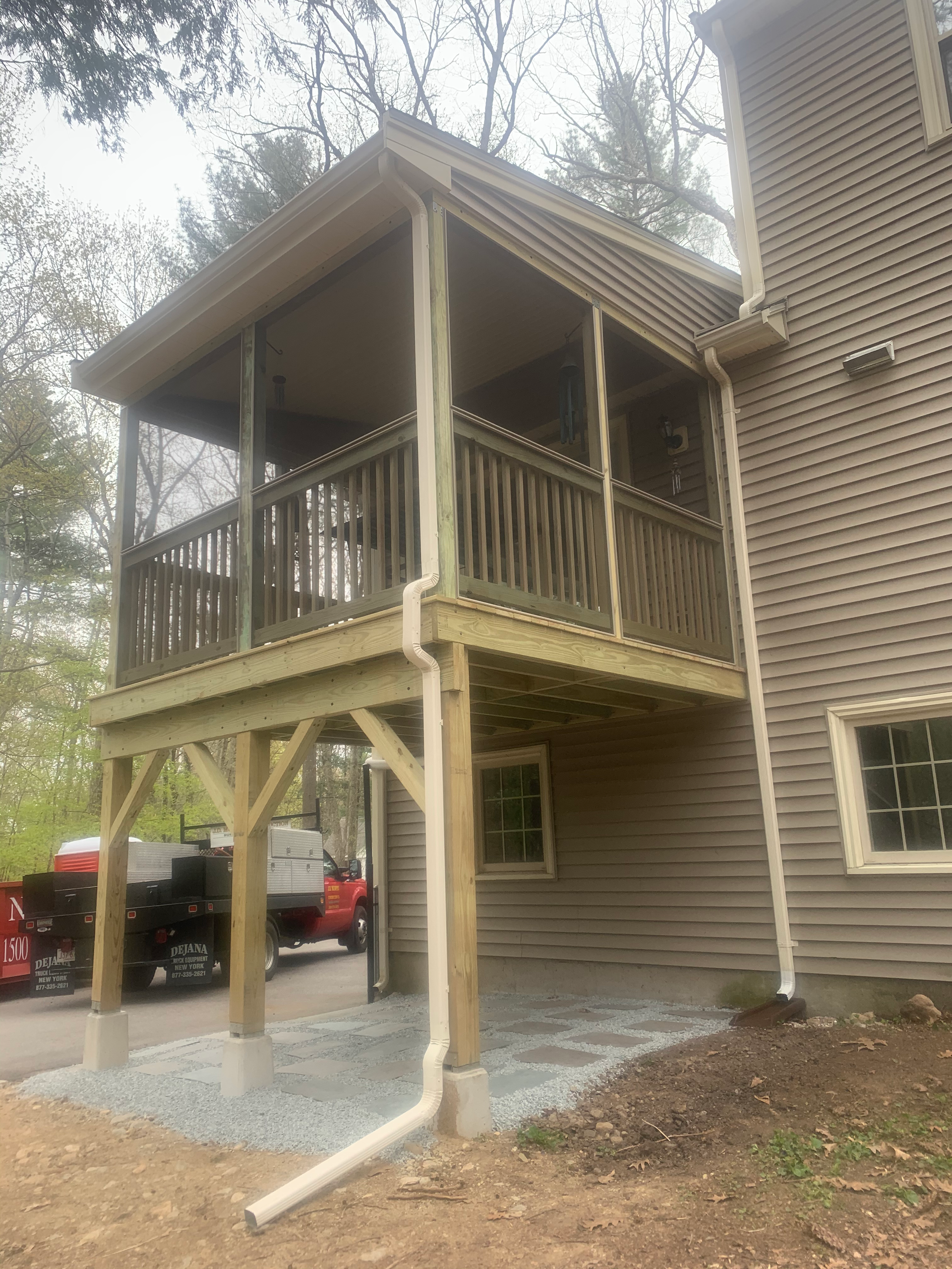 A house with a screened in porch on the side of it.