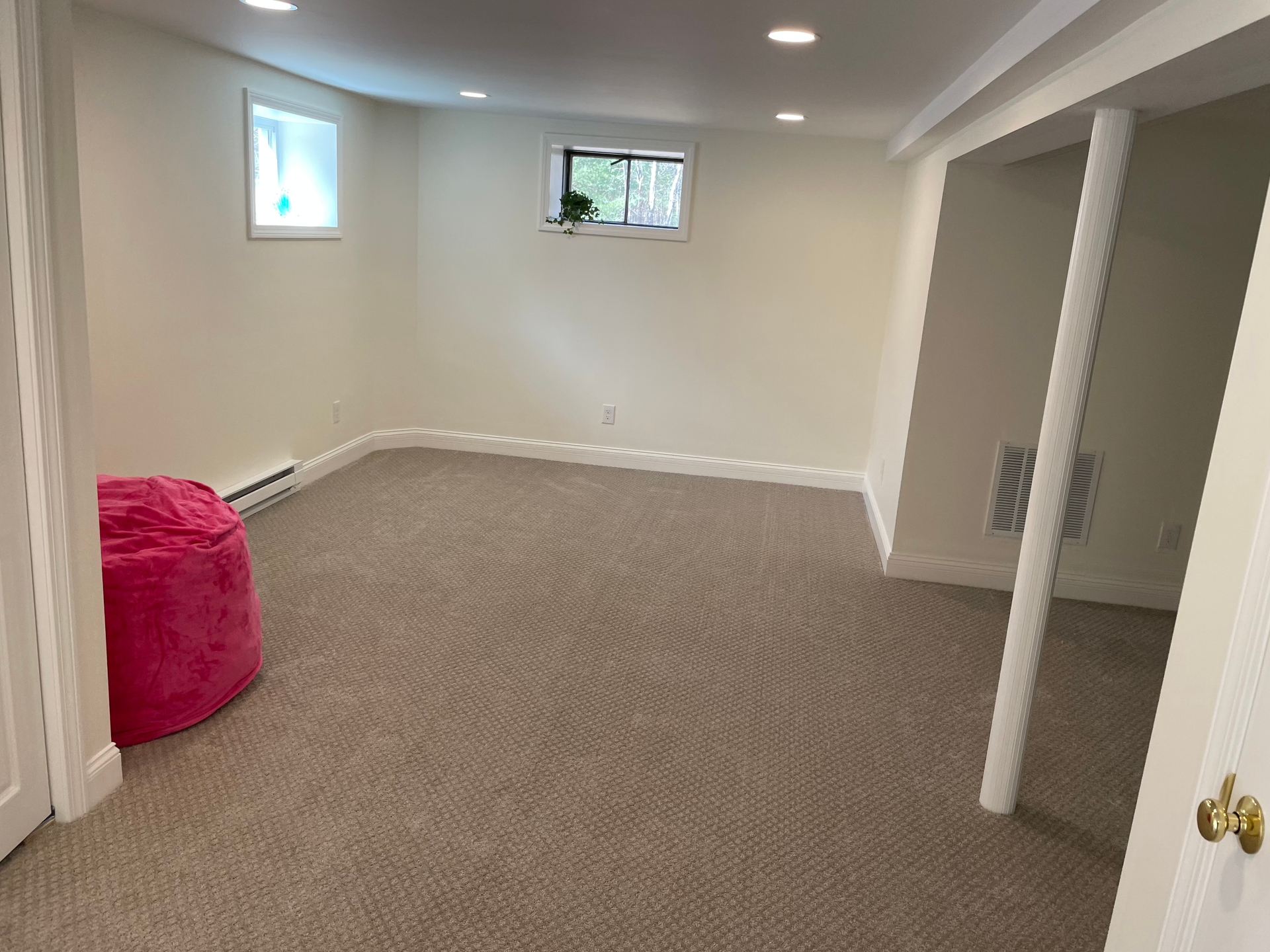 There is a pink bean bag chair in the middle of the room.