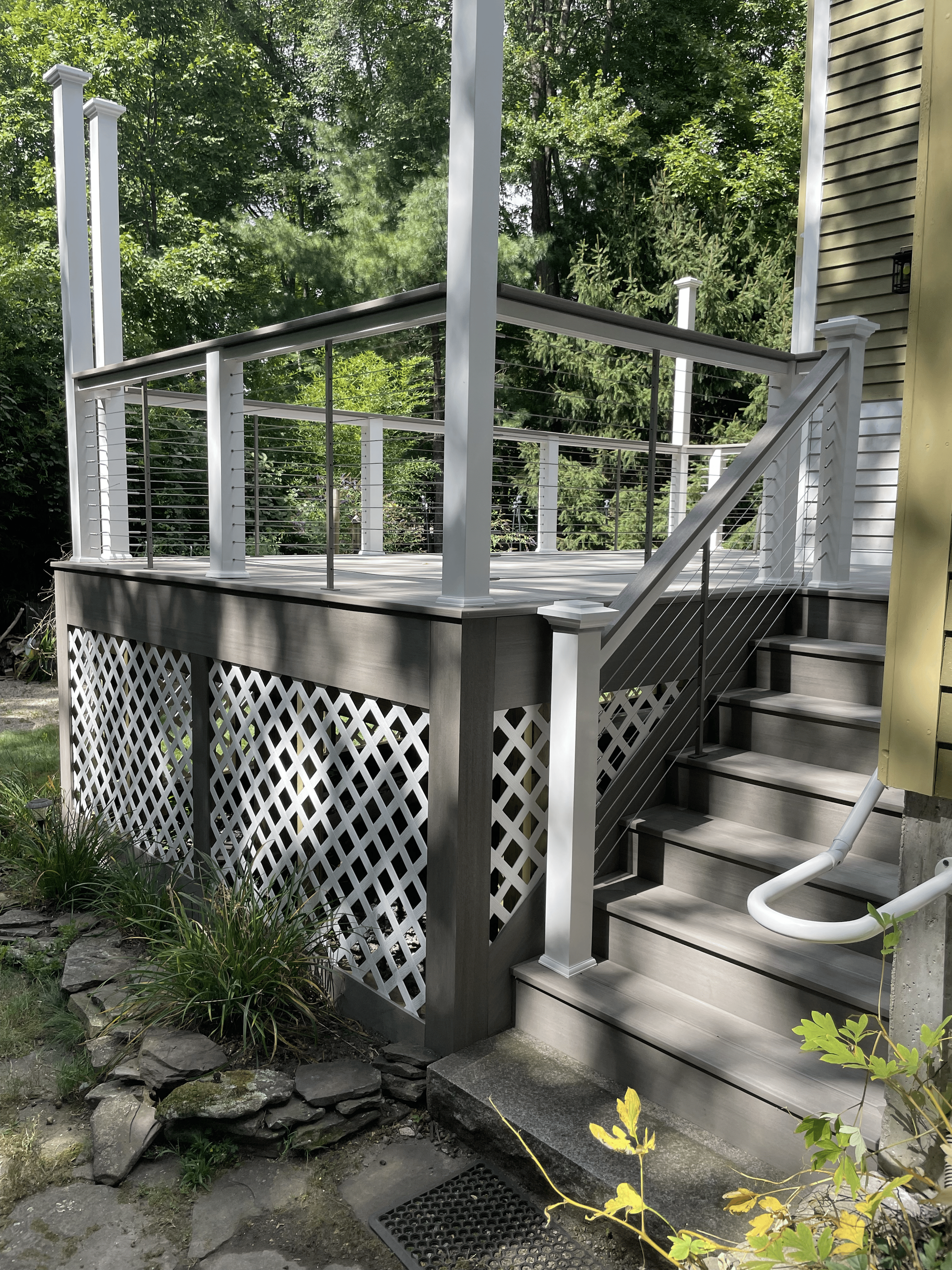 A deck with stairs leading up to it and trees in the background