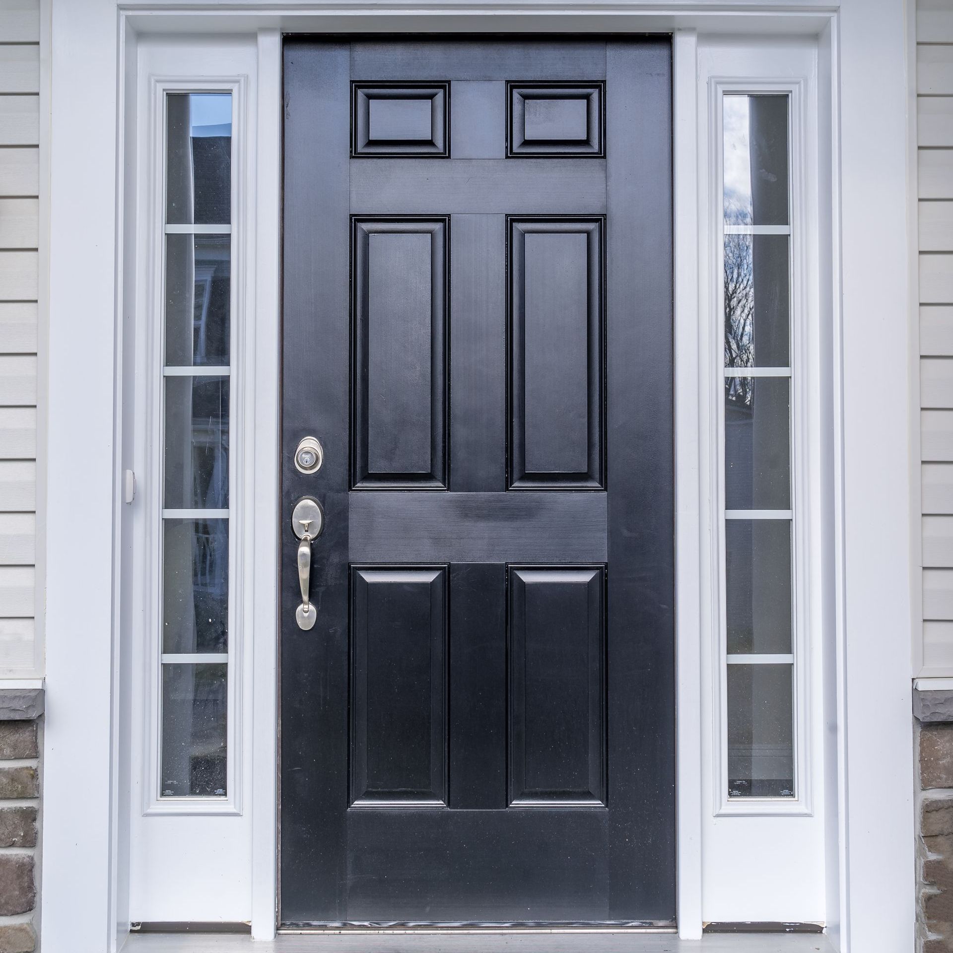 A black door on a white house with a white trim