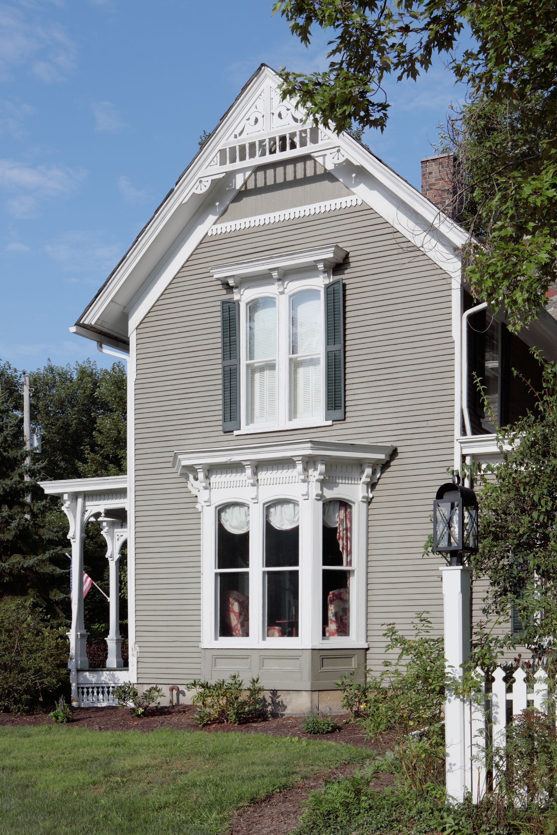 A small house with a white picket fence in front of it