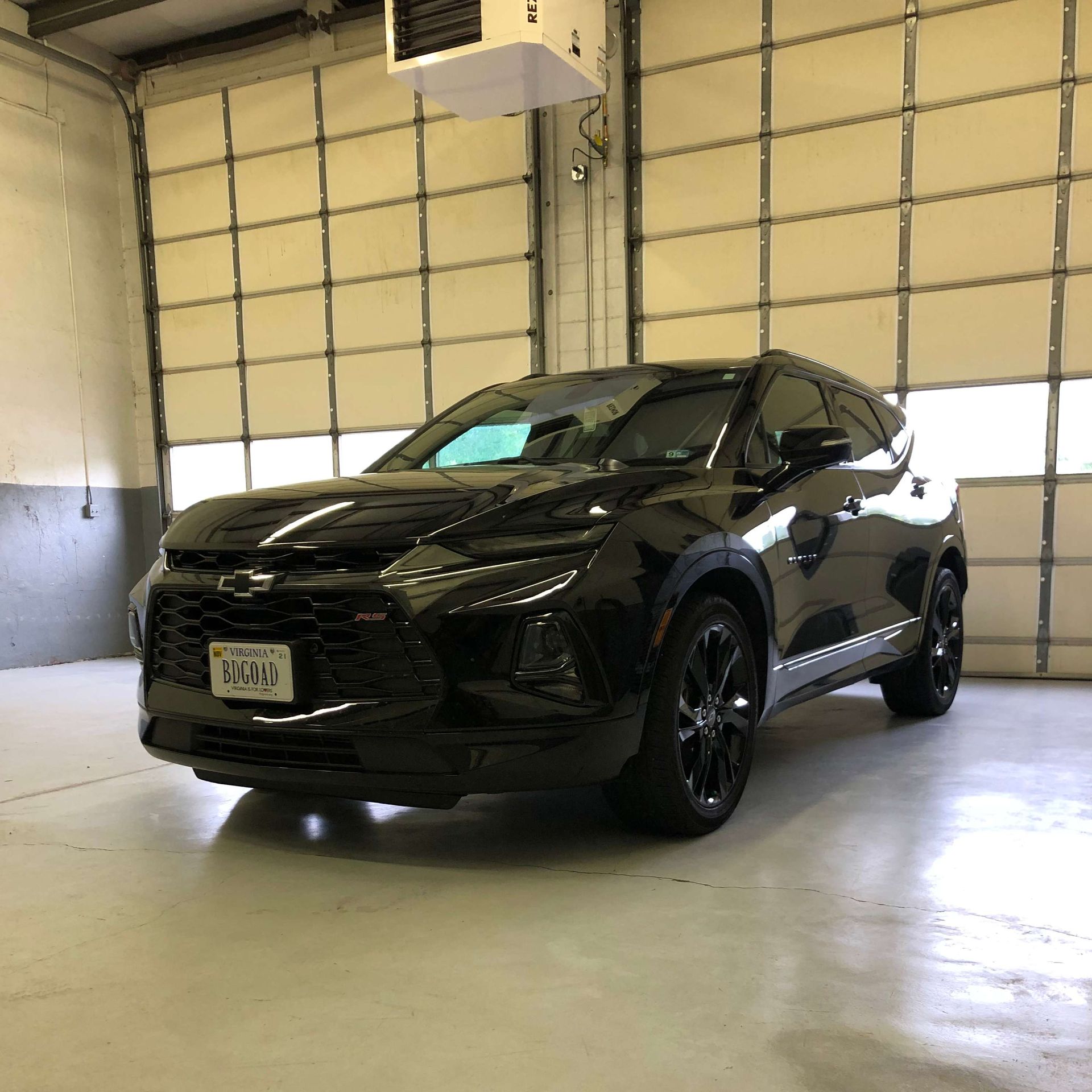 Black Chevy Blazer SUV parked in a garage.