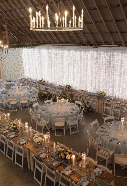 A large room with tables and chairs set up for a wedding reception.