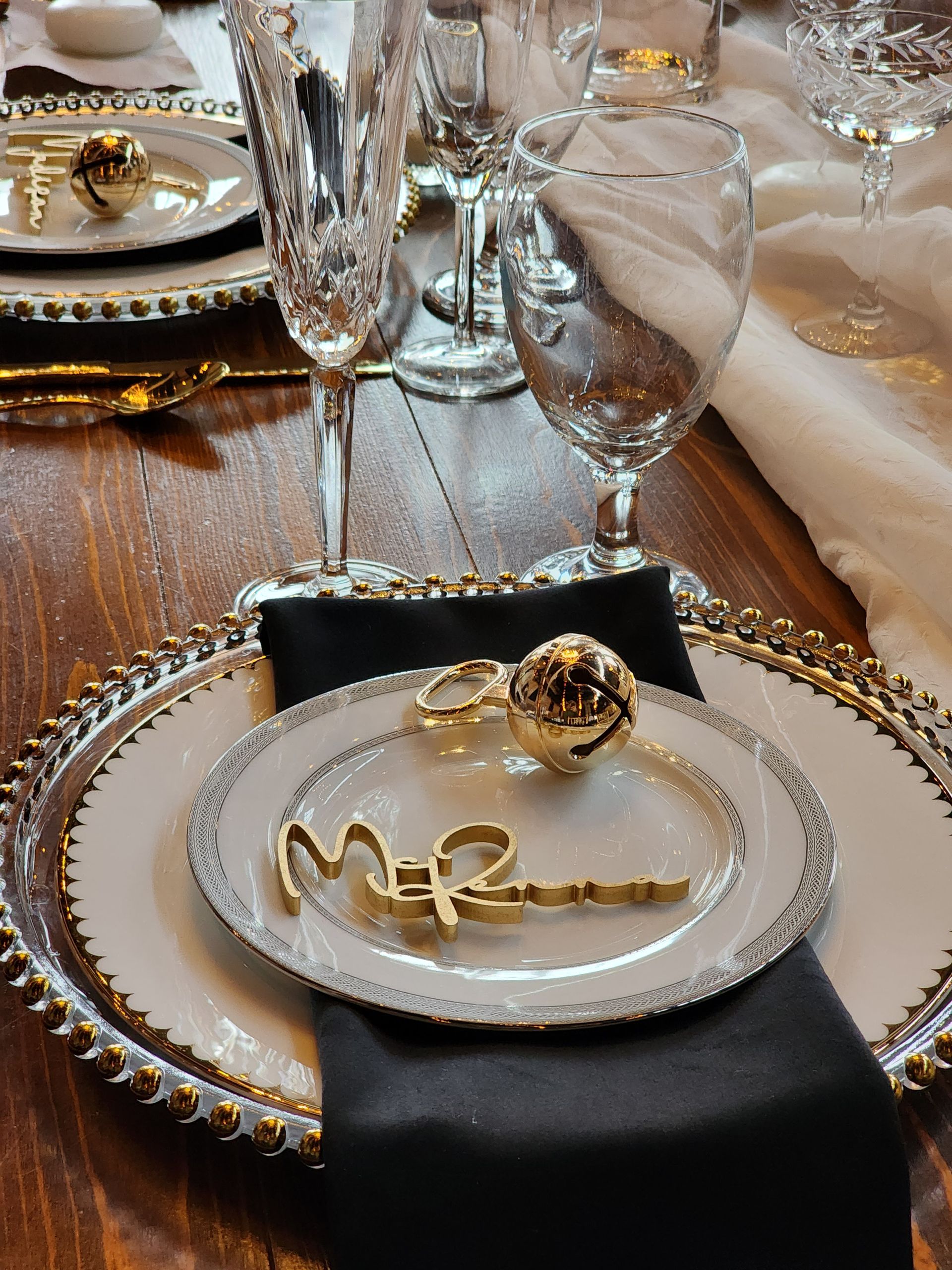 A place setting with plates and glasses on a wooden table