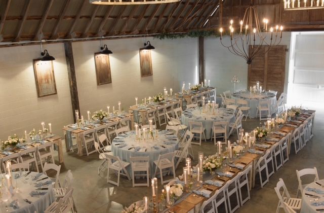 A large room with tables and chairs set up for a wedding reception.