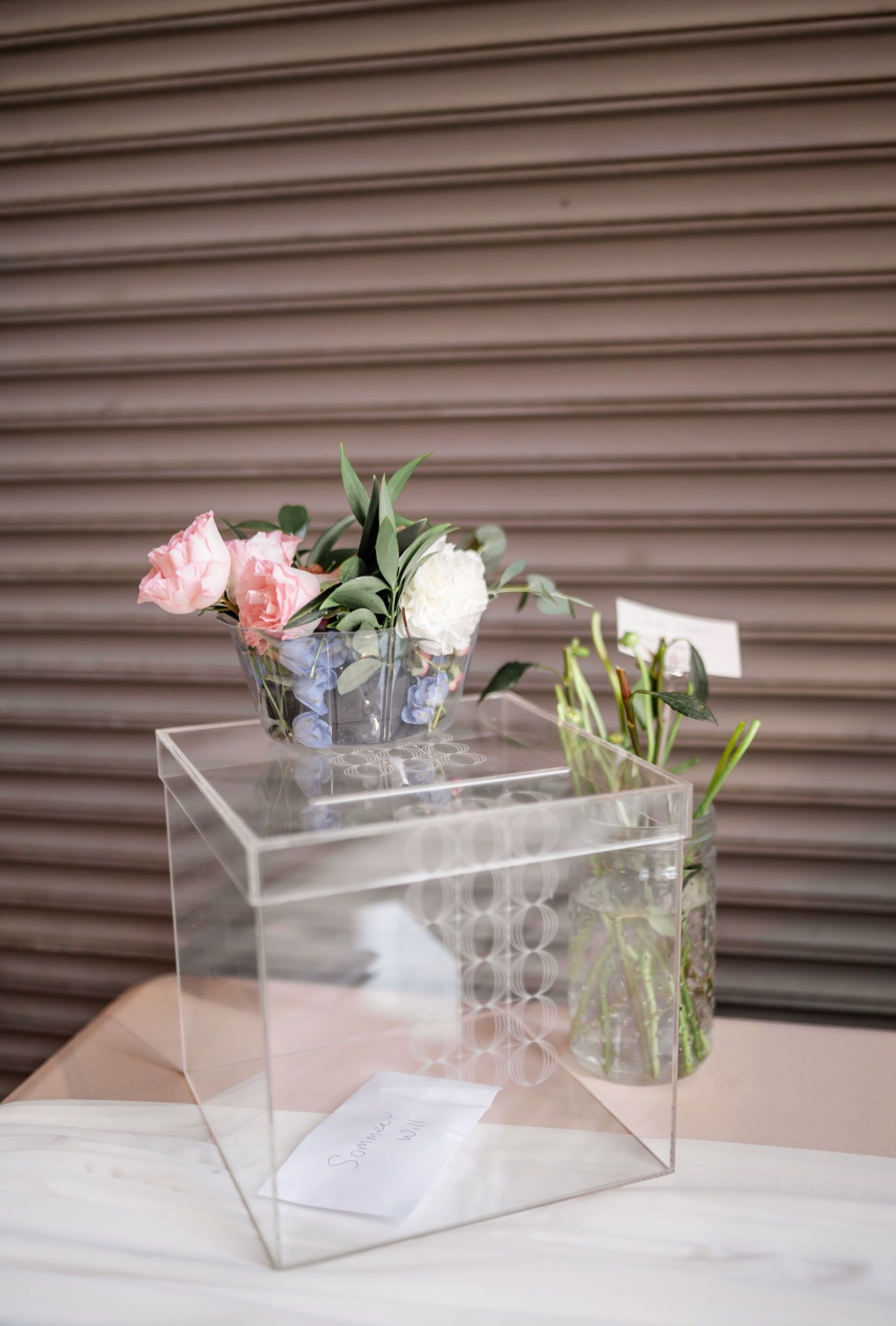 A clear acrylic box with flowers in it is sitting on a table.