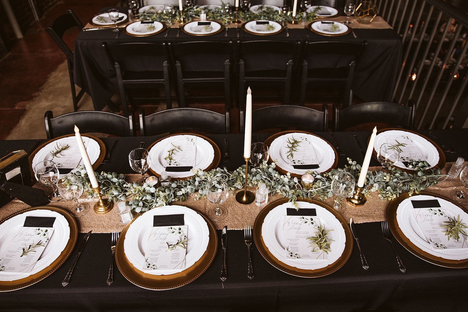 A long table with plates and candles on it.
