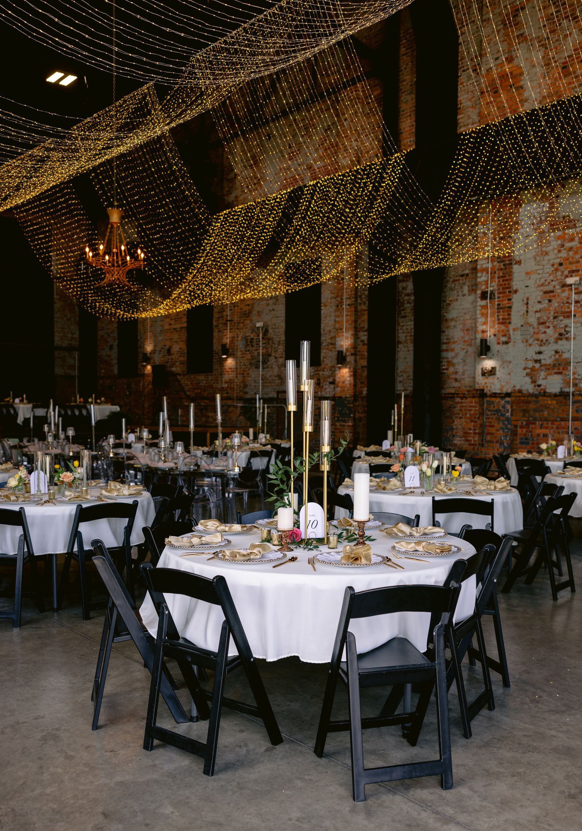 A large room with tables and chairs set up for a wedding reception.