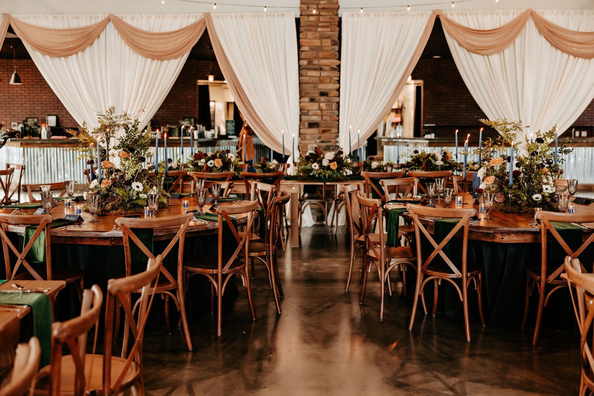 A large room with tables and chairs set up for a wedding reception.