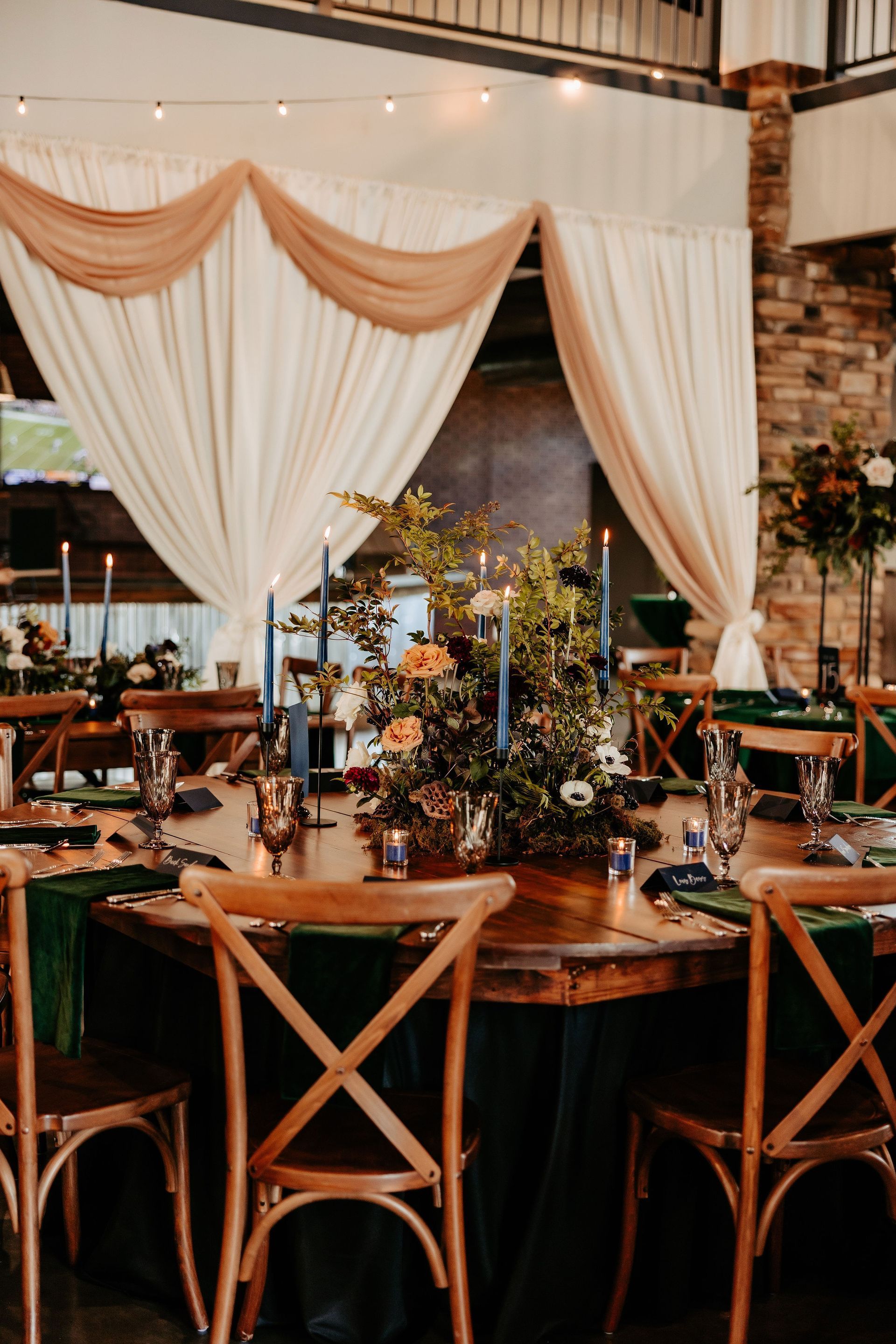 A table set for a wedding reception with candles and flowers on it.