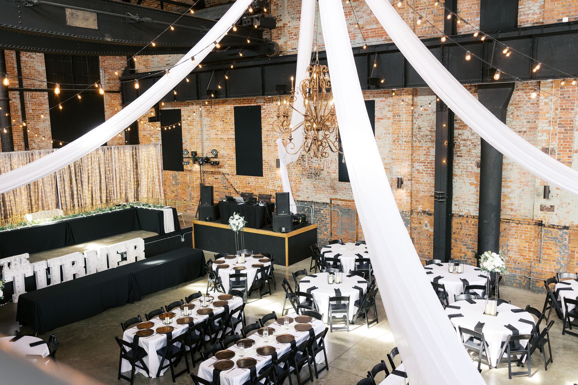 A large room with tables and chairs set up for a wedding reception.