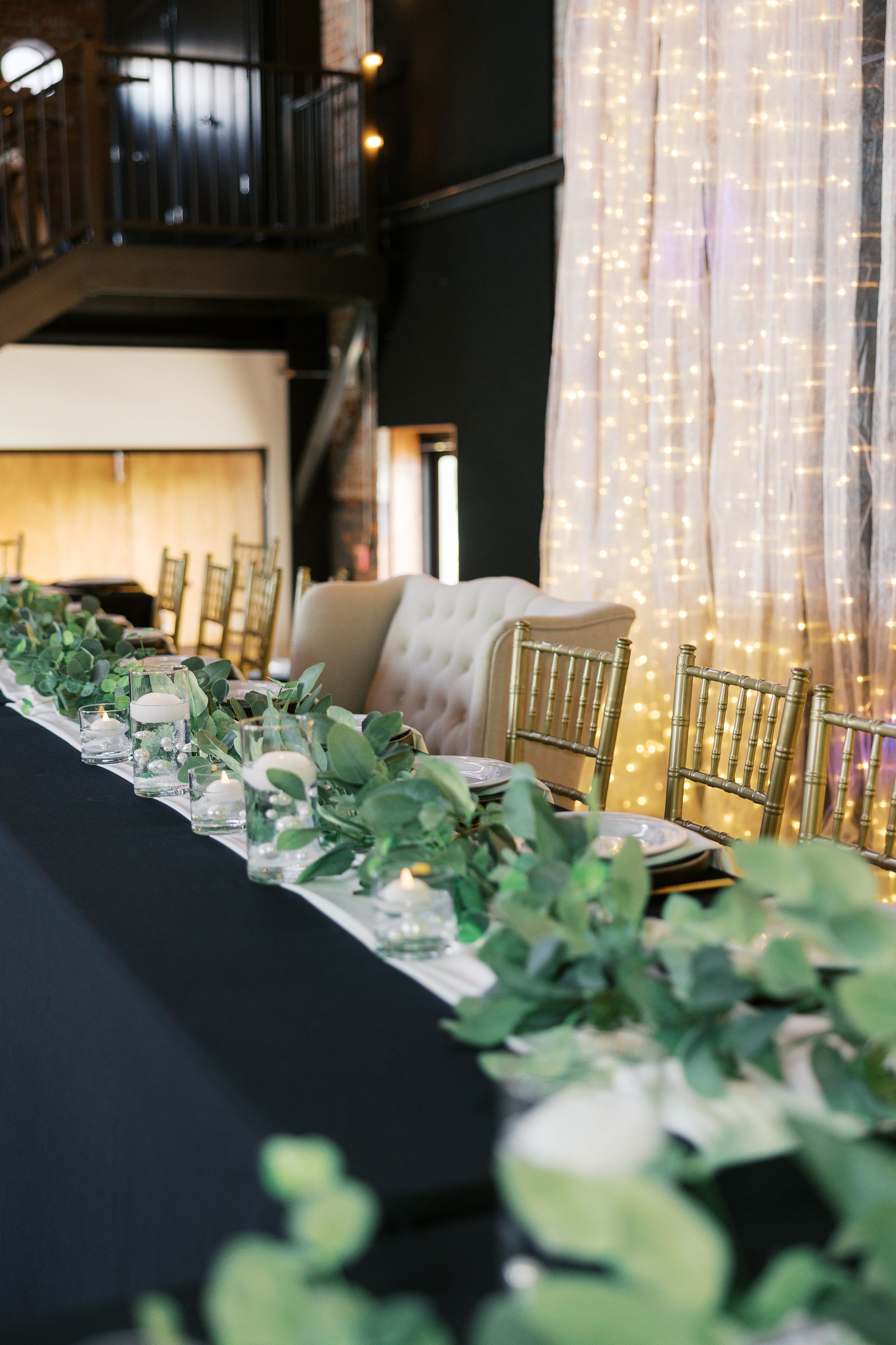 A long table with a garland of greenery and flowers on it.