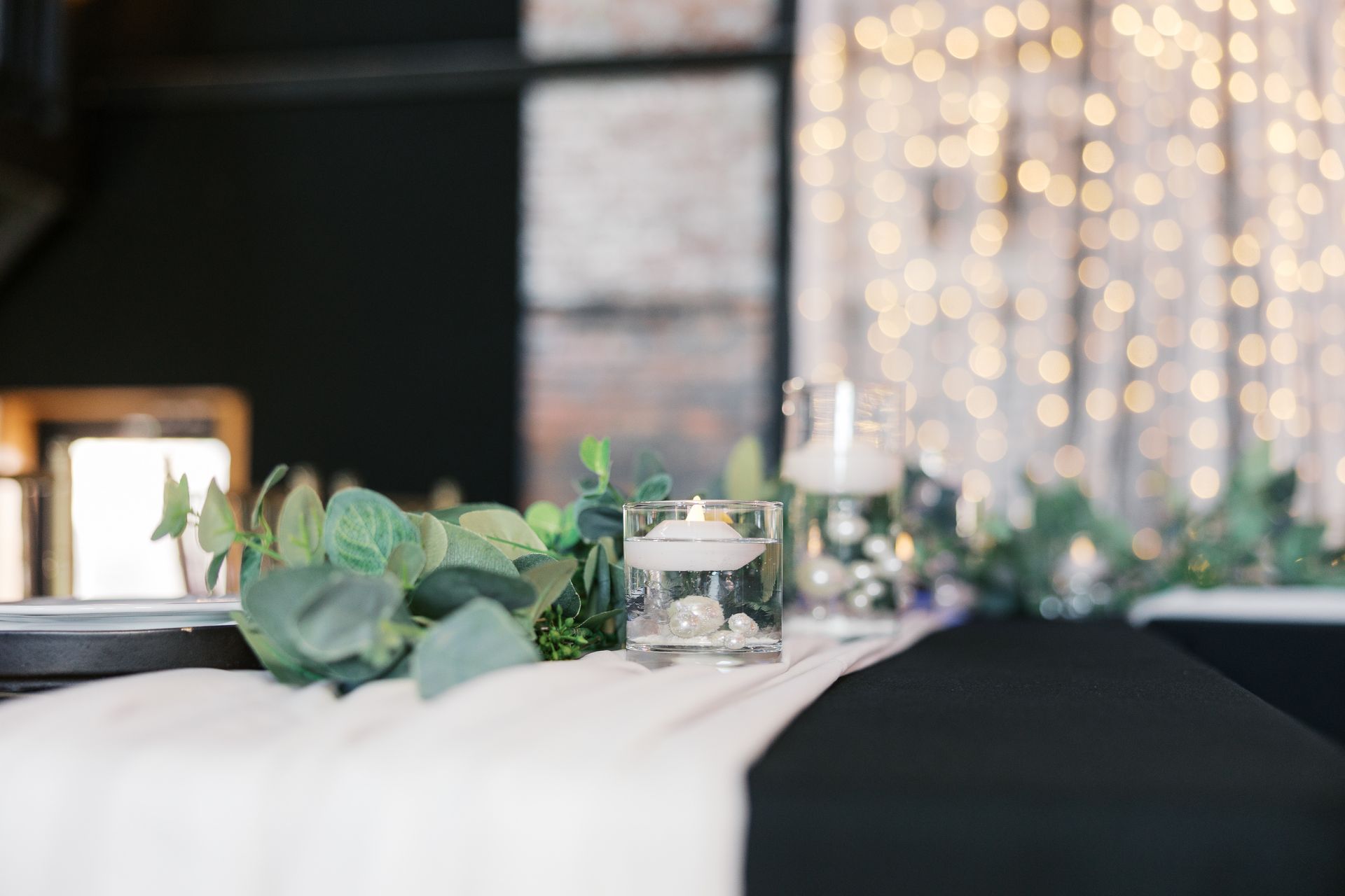 A table with a white table cloth and candles on it.