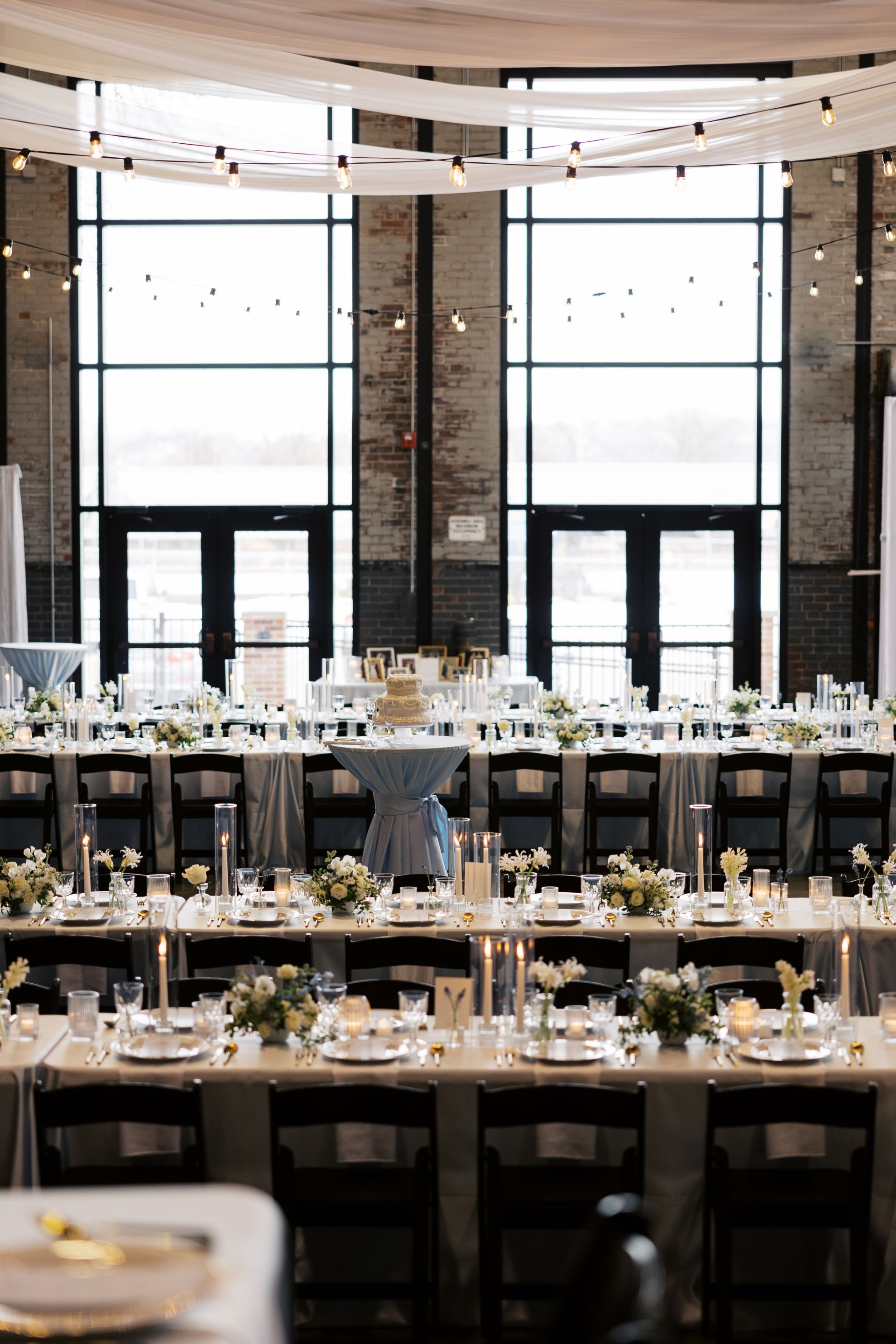 A large room with tables and chairs set up for a wedding reception.