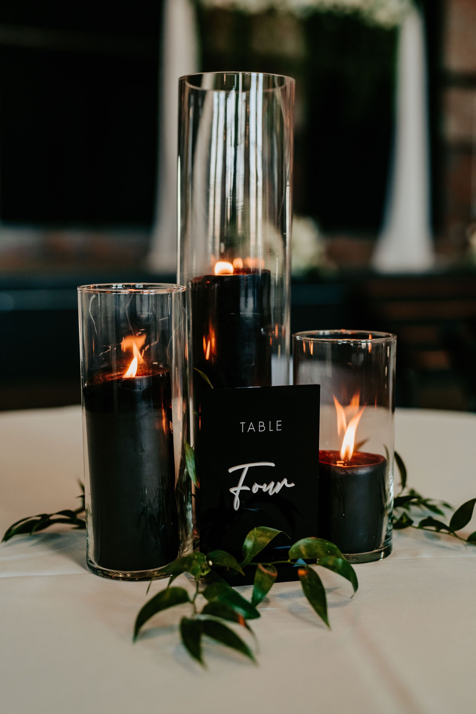 A table with three candles and a table number on it.