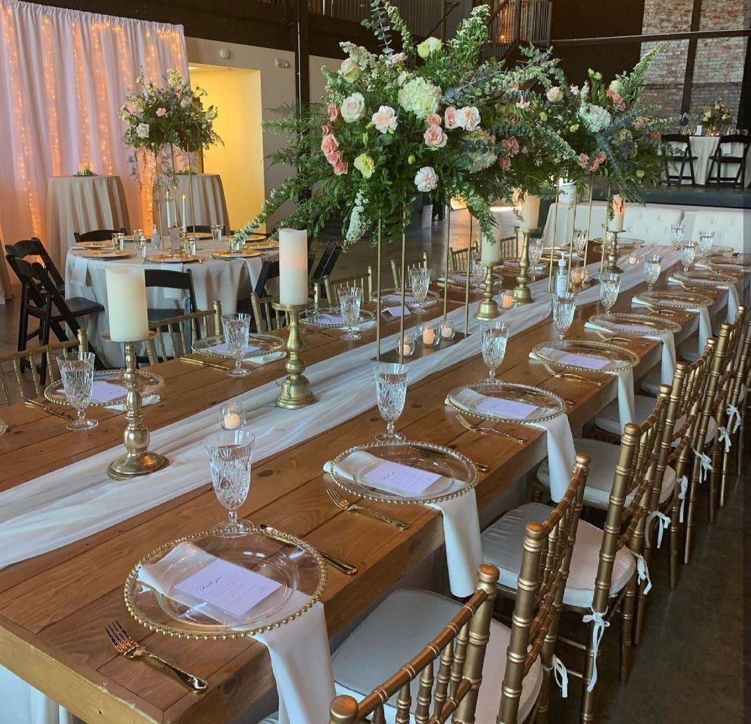 a table at an event with candle centerpieces and dinnerware