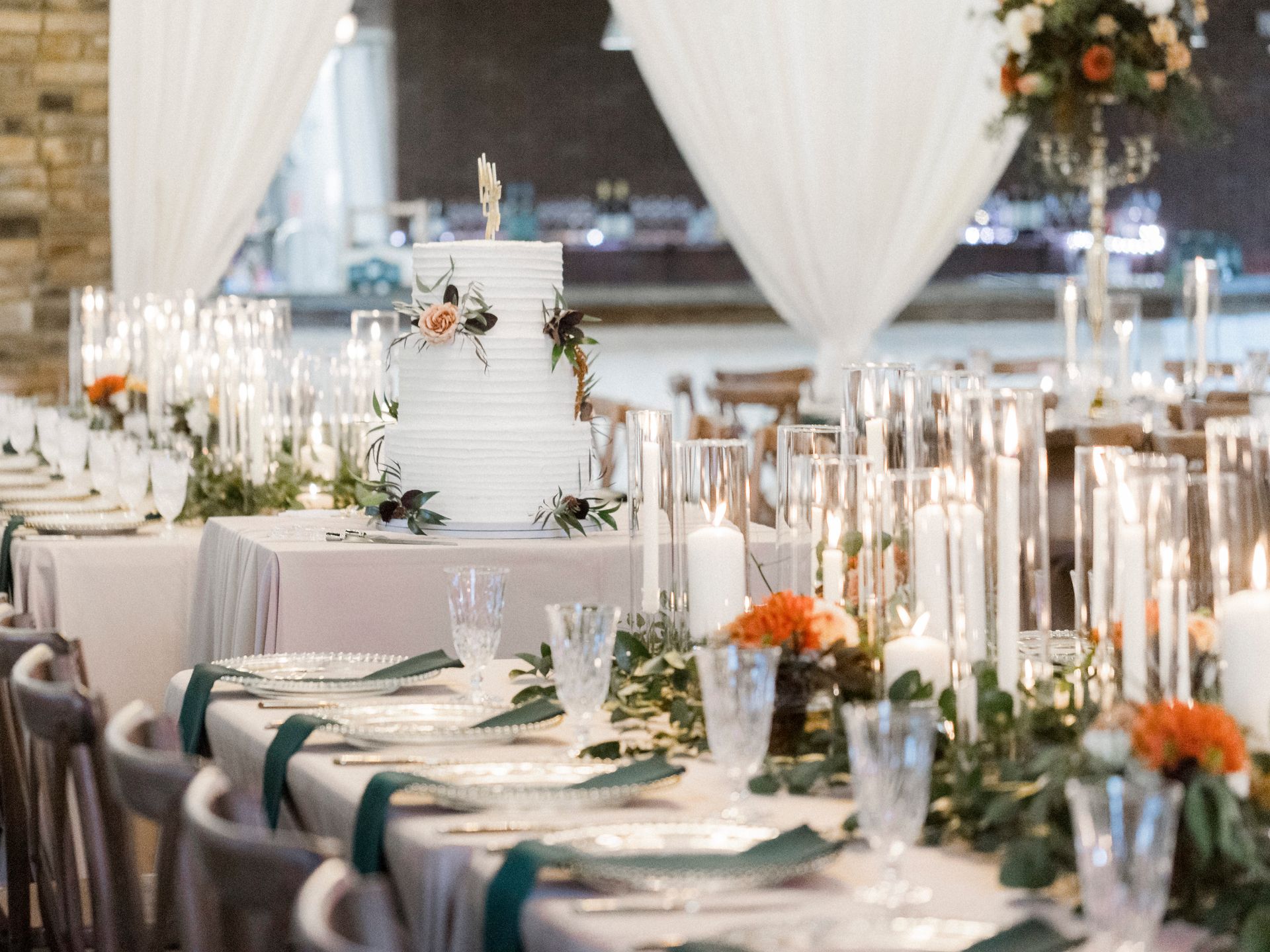 A table set for a wedding reception with a cake on top of it.