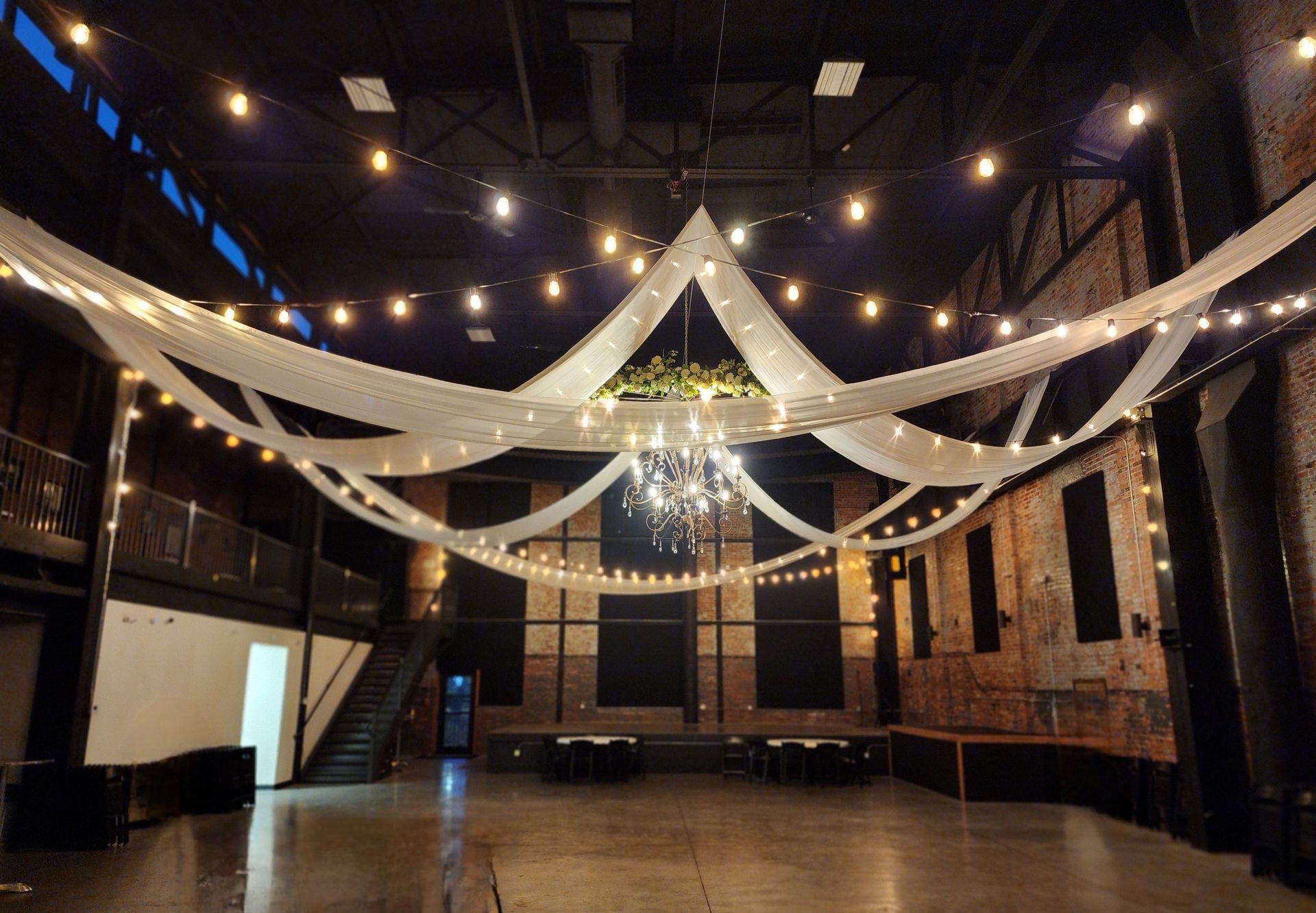 A large empty room with a chandelier hanging from the ceiling.