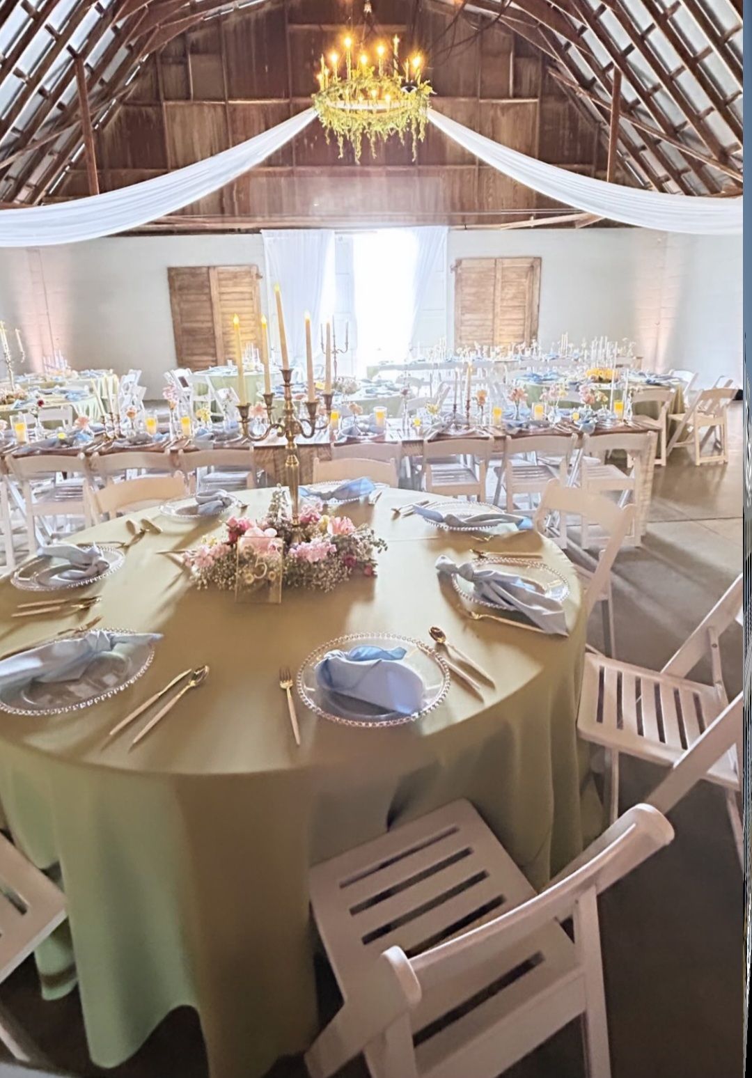A large room with tables and chairs set up for a wedding reception.