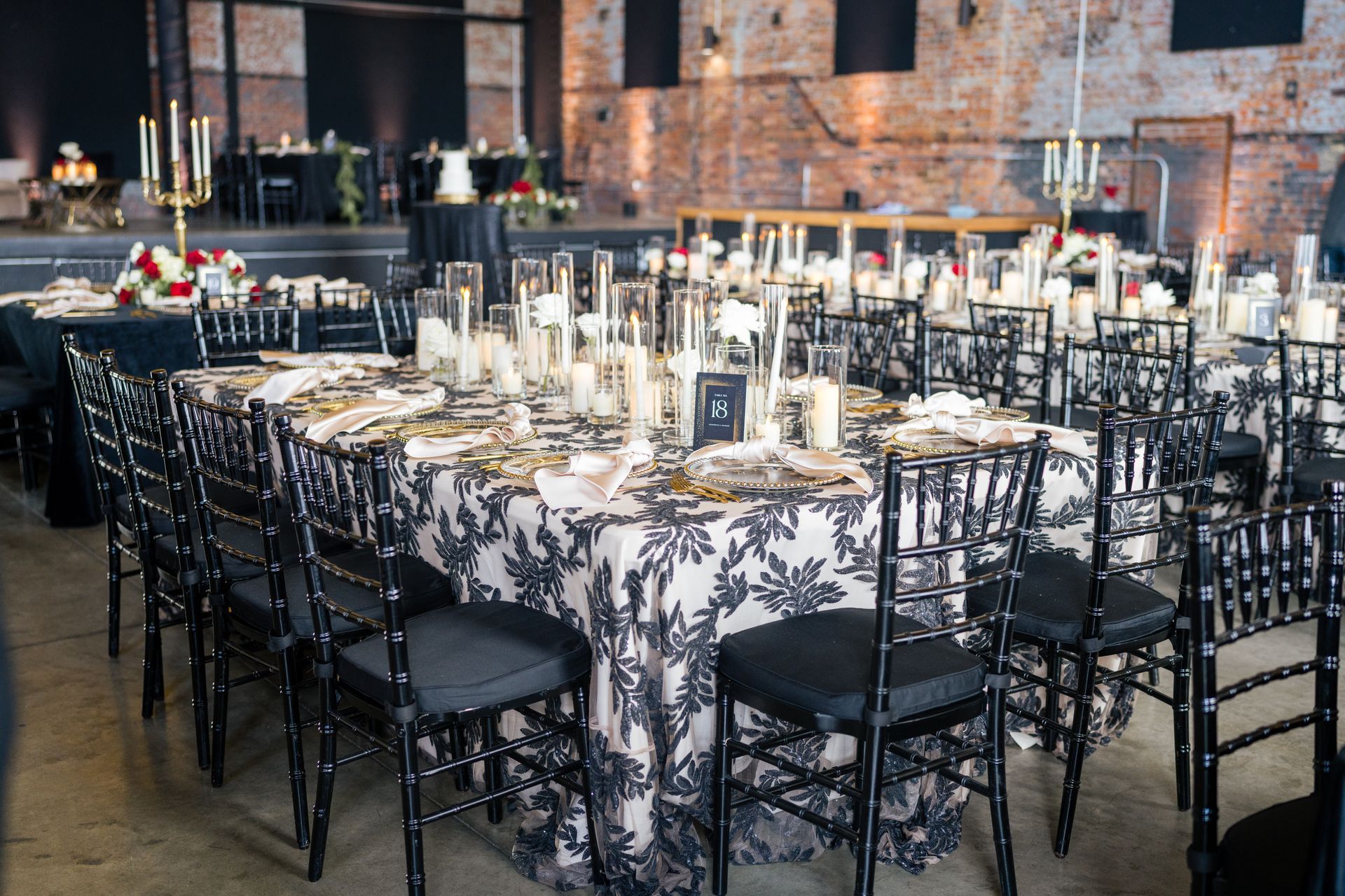 A large room with tables and chairs set up for a wedding reception.