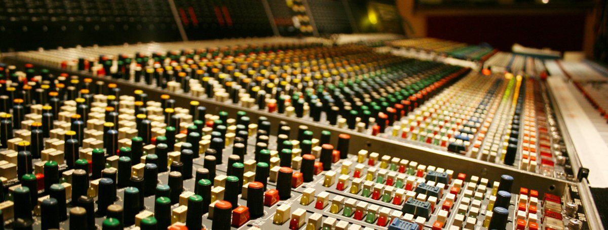 Une table de mixage dans un studio d'enregistrement avec beaucoup de boutons et de boutons.