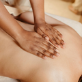 Hands giving a back massage with warm oil on bare skin