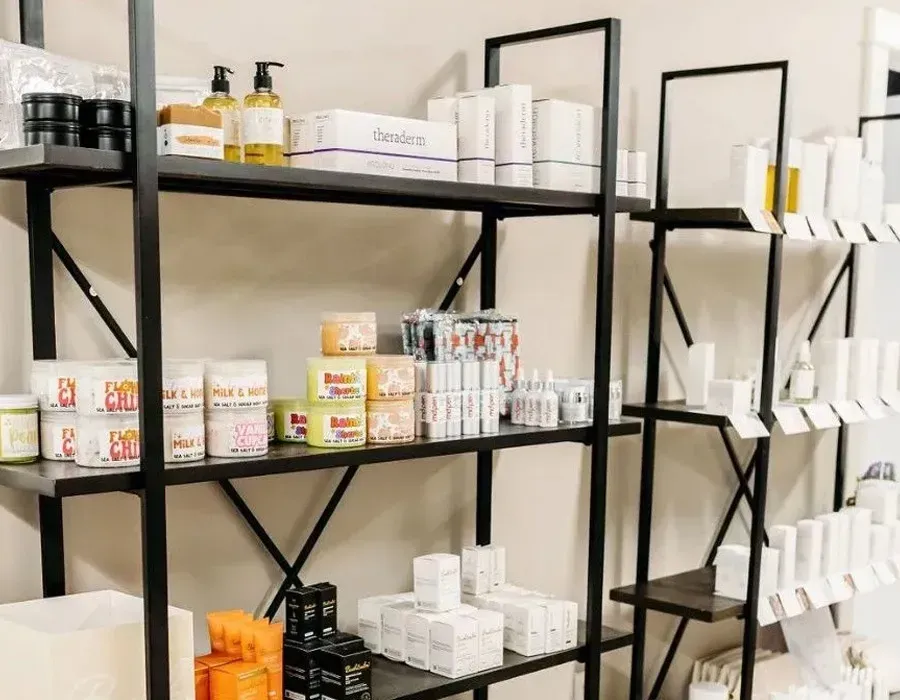 Black shelves stocked with assorted bottles, boxes, and jars in a bright shop interior