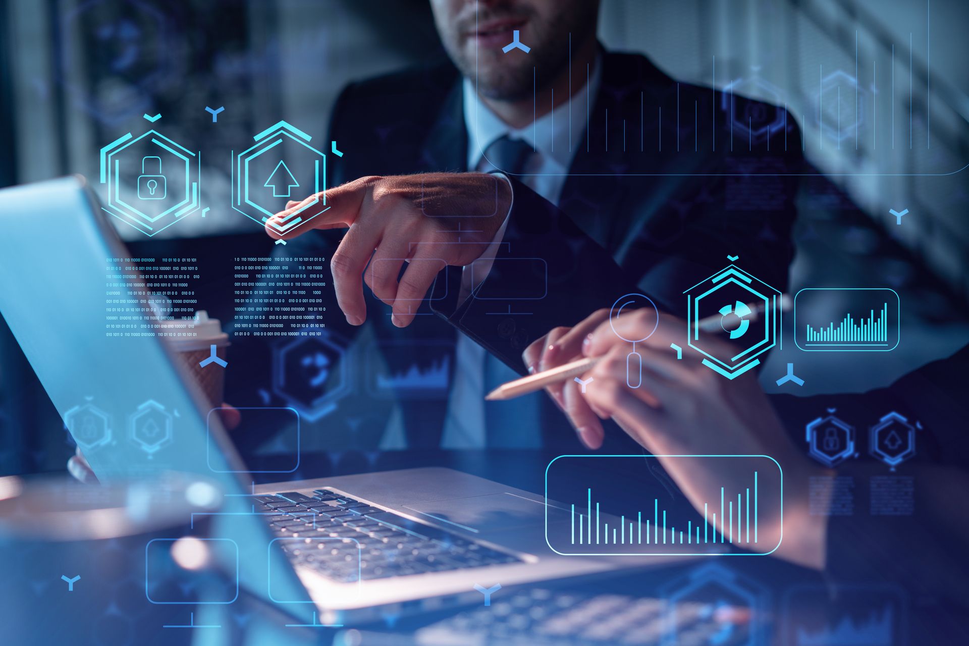 Two people in suits looking at a laptop, pointing at the screen with digital graphics overlaid.