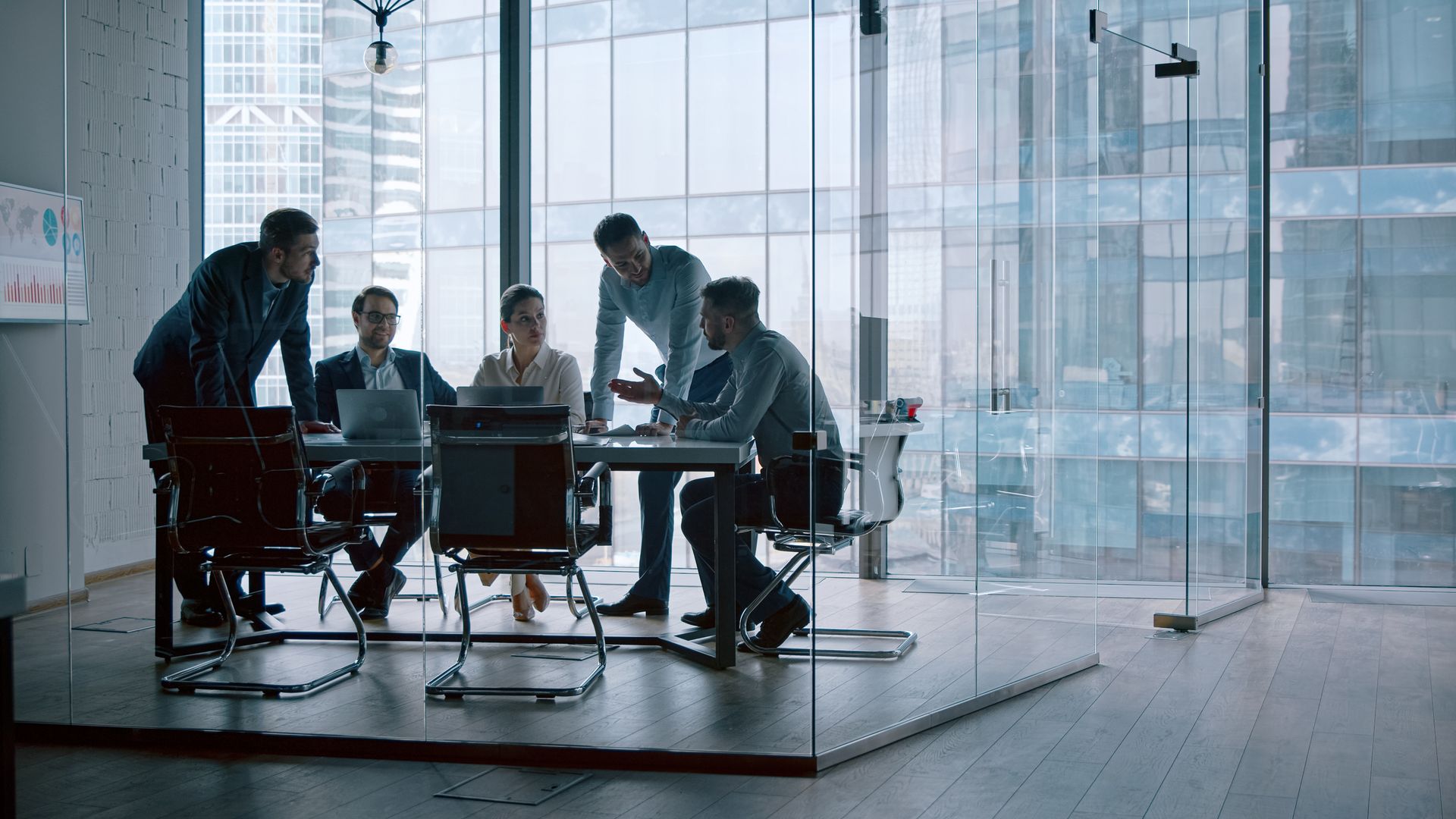 Business team in a meeting with a cloud icon at the center, surrounded by data flow lines and icons.