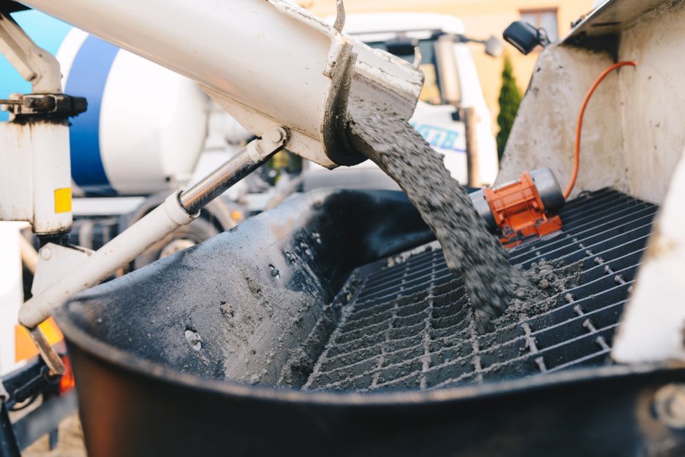 Concrete Pouring From a Truck Into a Receiving Bin — Nambucca Concrete Pumping in Grafton, NSW