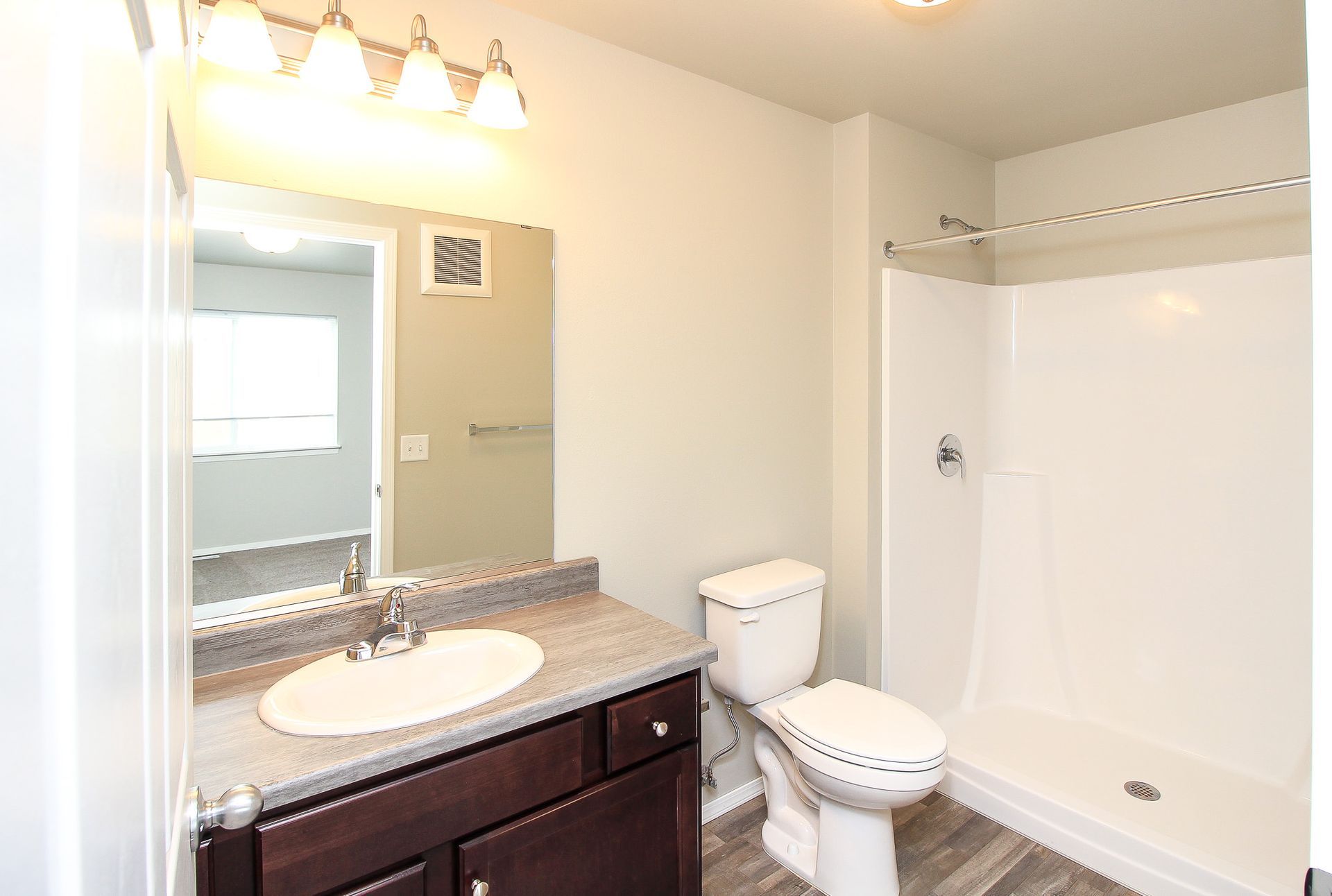 Bathroom with vanity, mirror, toilet, and white shower curtain in a bright interior
