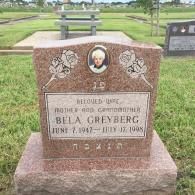 A rose-colored granite headstone for Bela Greyberg in a cemetery, featuring an inset photo and etched floral designs.