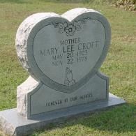 A heart-shaped gray granite headstone engraved