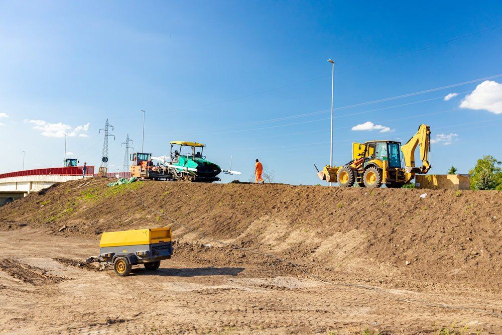 A group of construction vehicles are working on a dirt field — Bennettron Demex in Corindi Beach, NSW