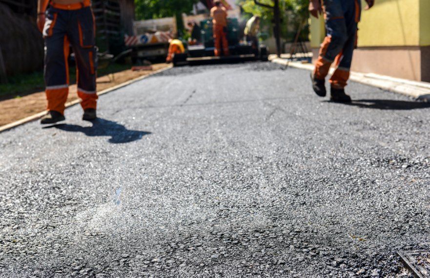 A driveway with two workers walking along side road — Bennettron Demex in Corindi Beach, NSW