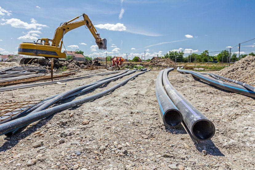 A construction site with a bulldozer and pipes in the dirt — Bennettron Demex in Corindi Beach, NSW