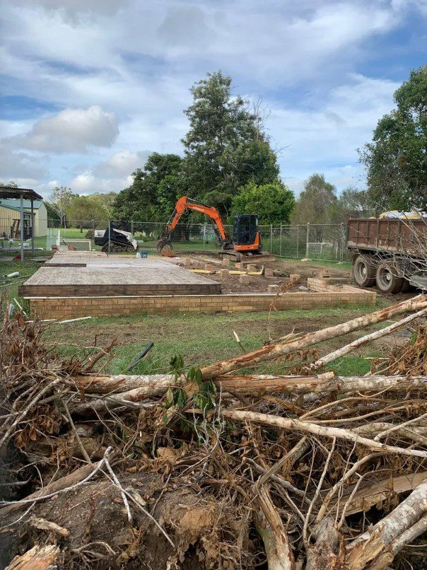 A Pile of Logs is Sitting in Front of a Construction Site — Bennettron Demex in Corindi Beach, NSW