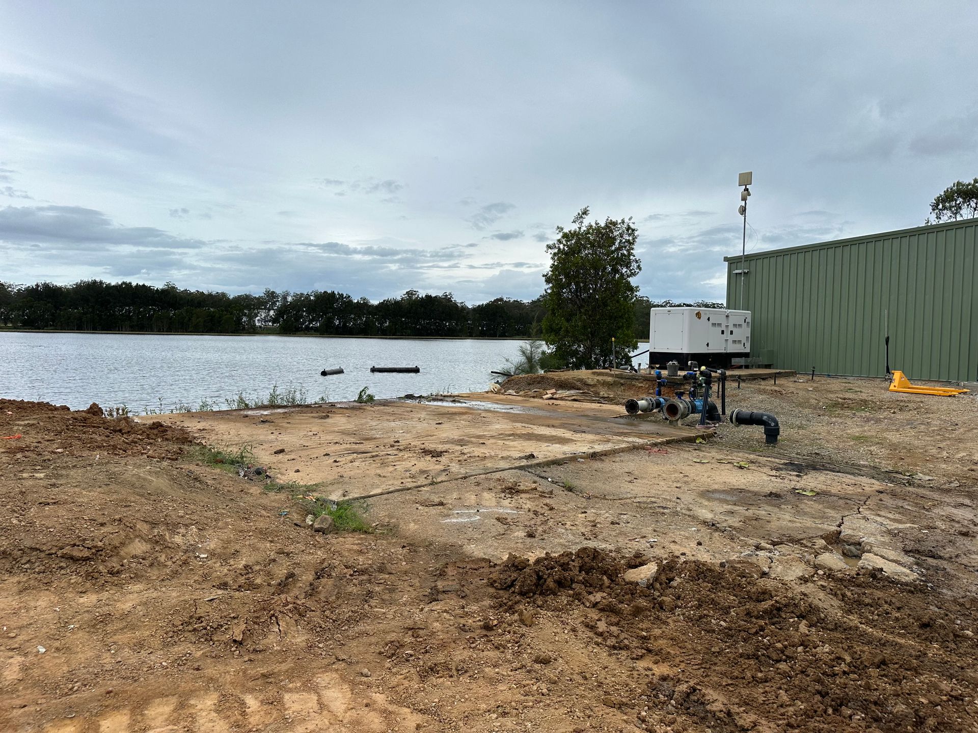 A Construction Site With a Lot of Dirt and Trees in the Background with a river — Bennettron Demex in Corindi Beach, NSW