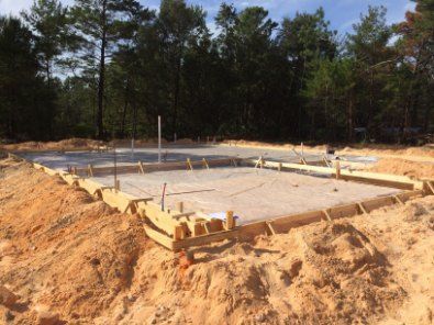 A concrete foundation is being built in the middle of a dirt field — Bennettron Demex in Corindi Beach, NSW