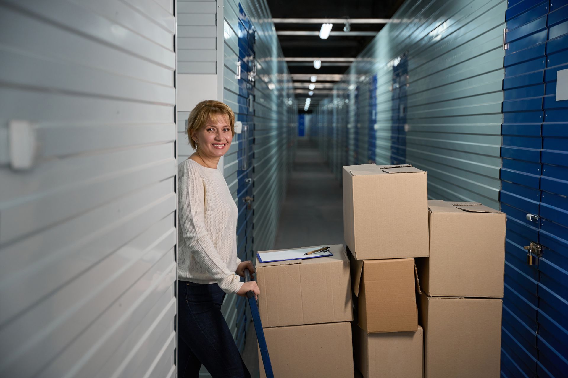 Person moving boxes in a self storage facility hallway