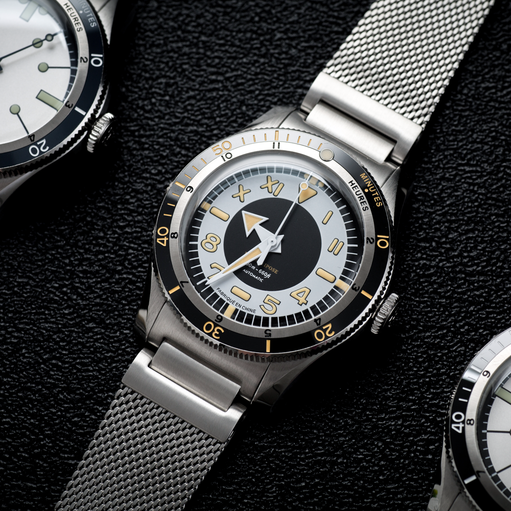 Three watches are sitting on top of each other on a black surface.