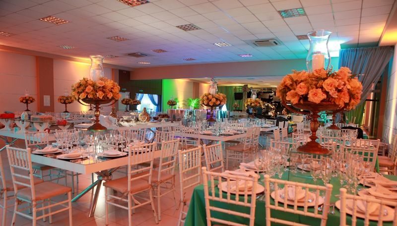 Sala de conferências com mesas e cadeiras azuis dispostas em forma de U.