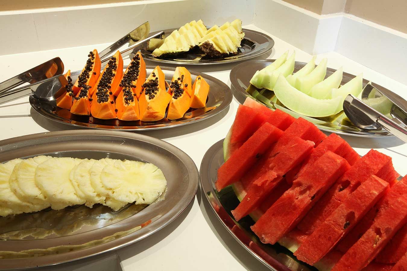 Bandeja de pãezinhos dourados em uma vitrine de padaria.