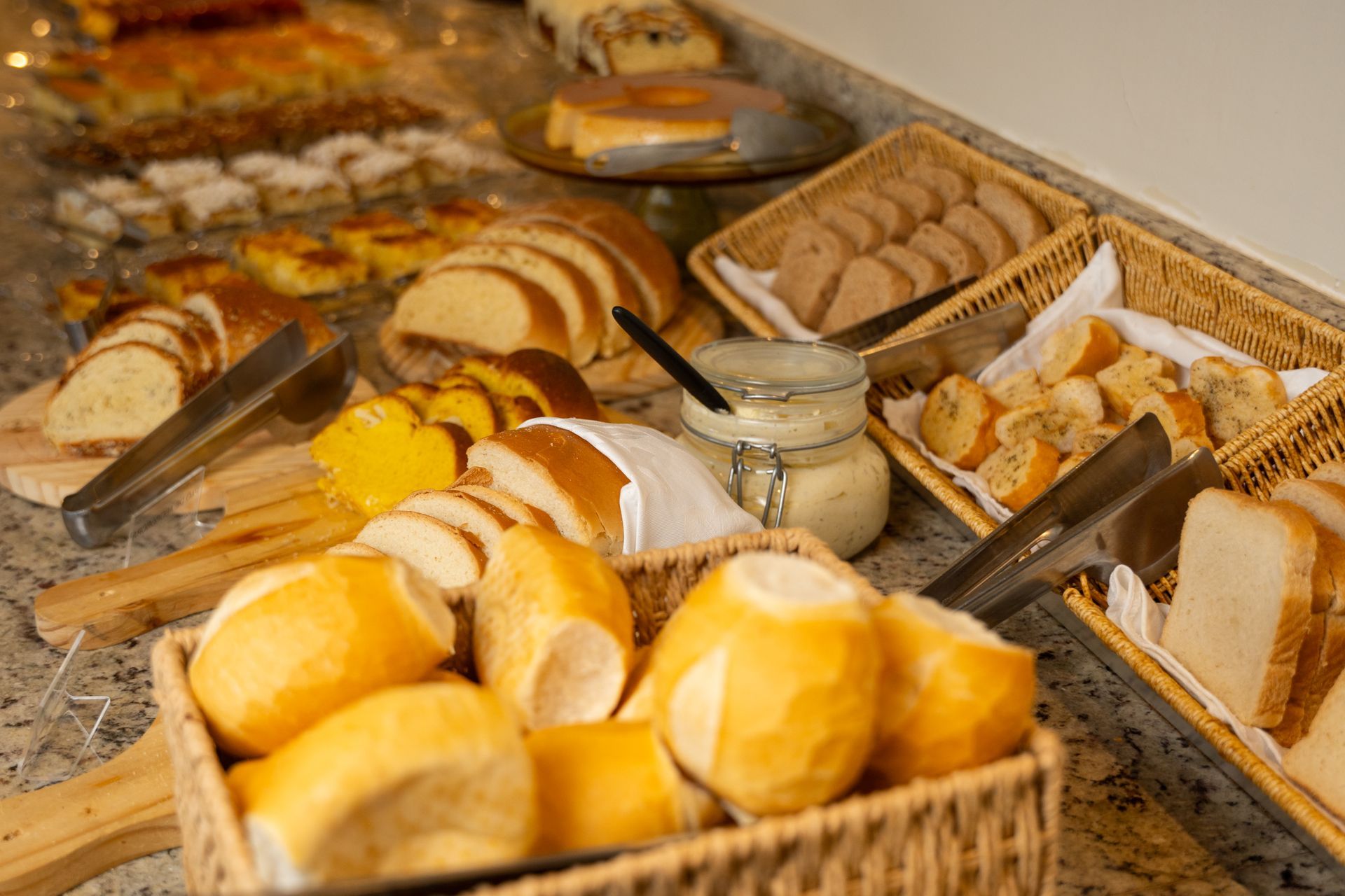 Bandeja de pãezinhos dourados em uma vitrine de padaria.