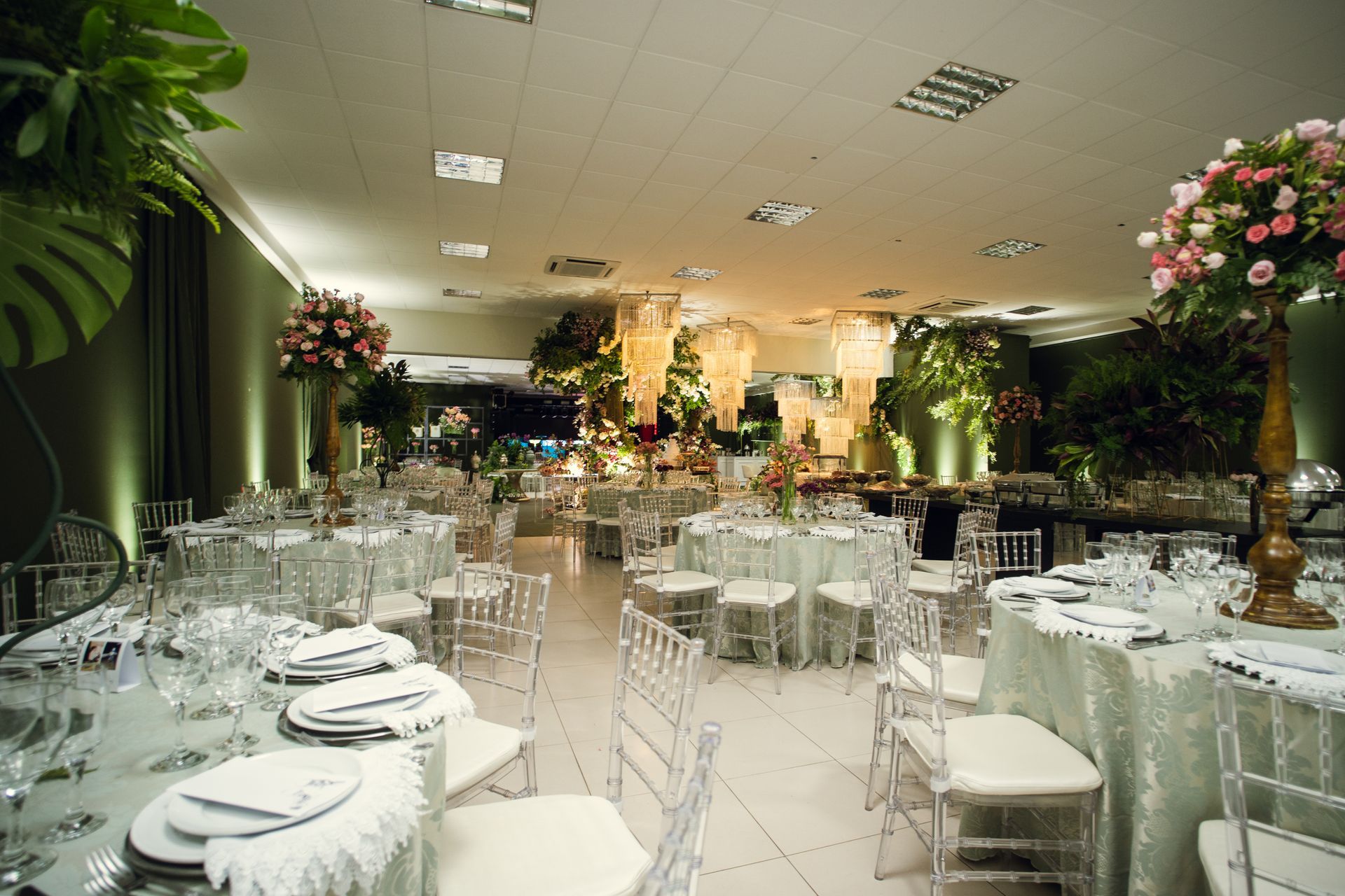 Sala de conferências com fileiras de mesas e cadeiras, toalhas de mesa azuis.
