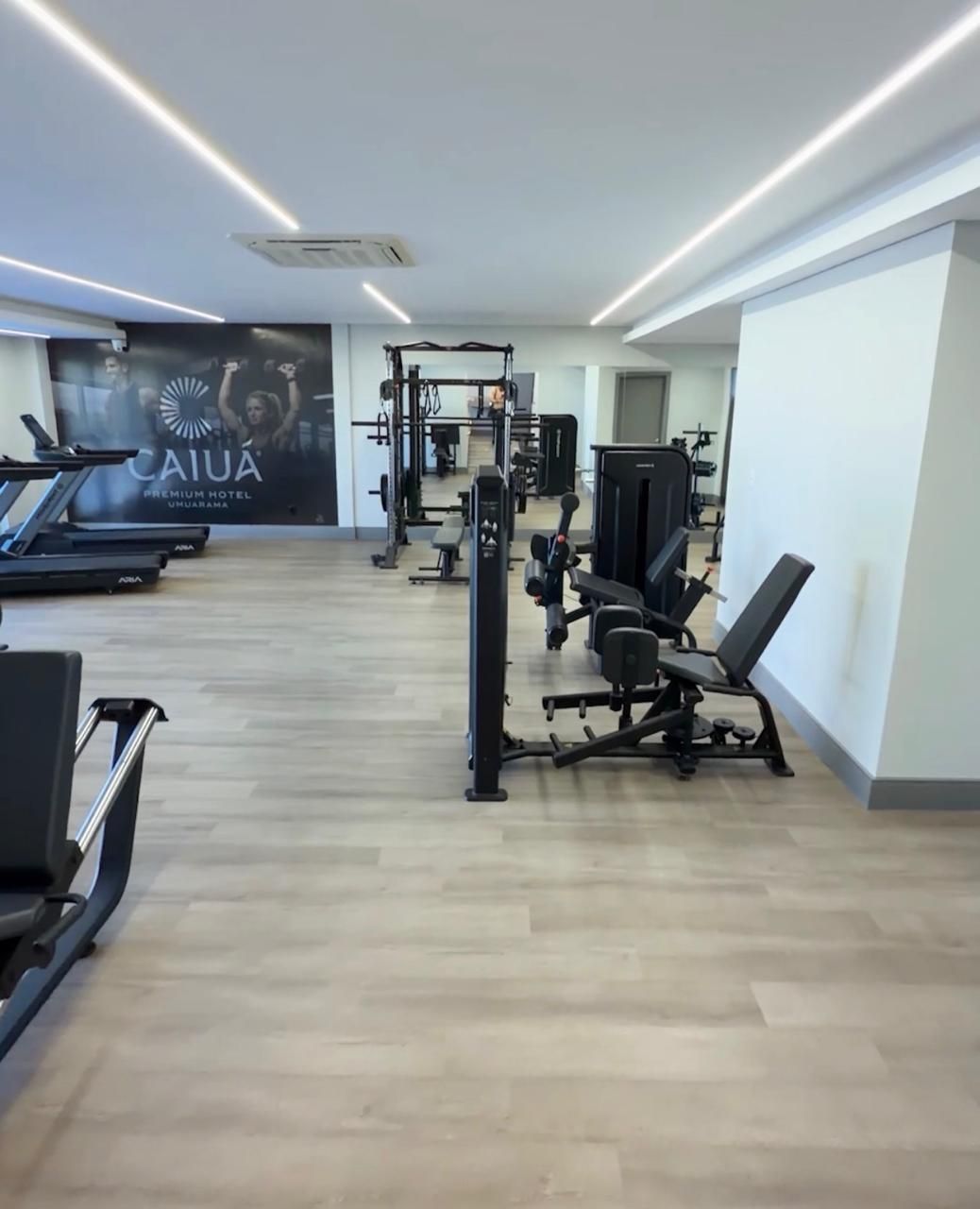 Sala de conferências preparada para uma reunião, com mesas dispostas em forma de U e cadeiras.