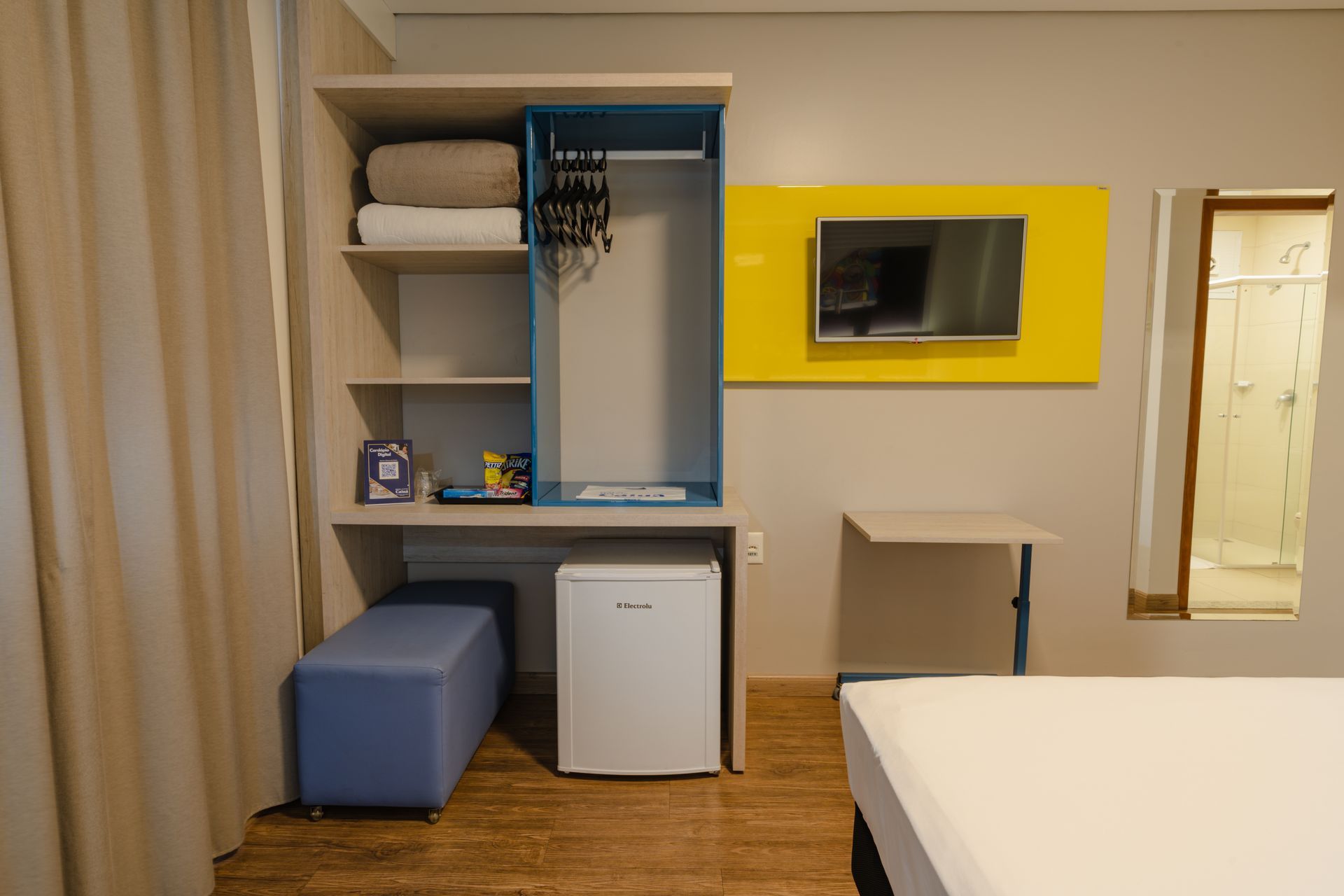 Uma sala de conferências com mesas e cadeiras, um projetor e papéis.