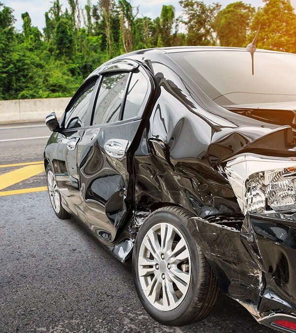 Severely Damaged Black Sedan on Wet Road After a Crash, With Crumpled Rear and Side Panels — Walker Bros. in Casino, NSW