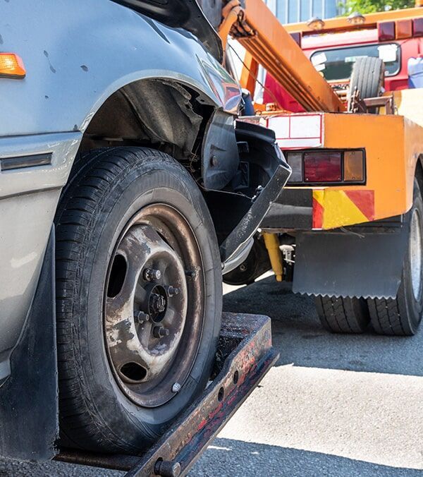 Damaged Blue Car Tire Against an Orange Tow Truck on a Roadside — Walker Bros. in Casino, NSW
