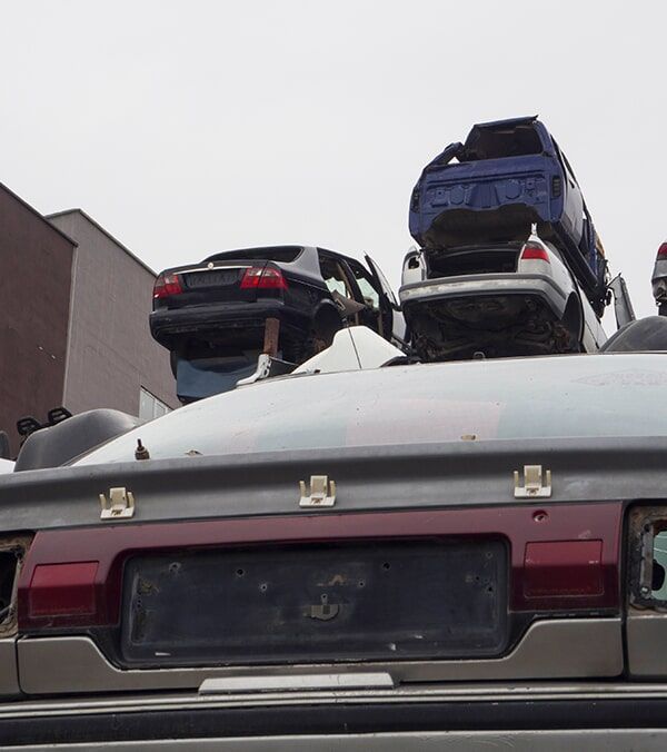 Cars Stacked Atop Each Other in a Scrapyard, With the Rear of a Silver Car in the Foreground — Walker Bros. in Casino, NSW
